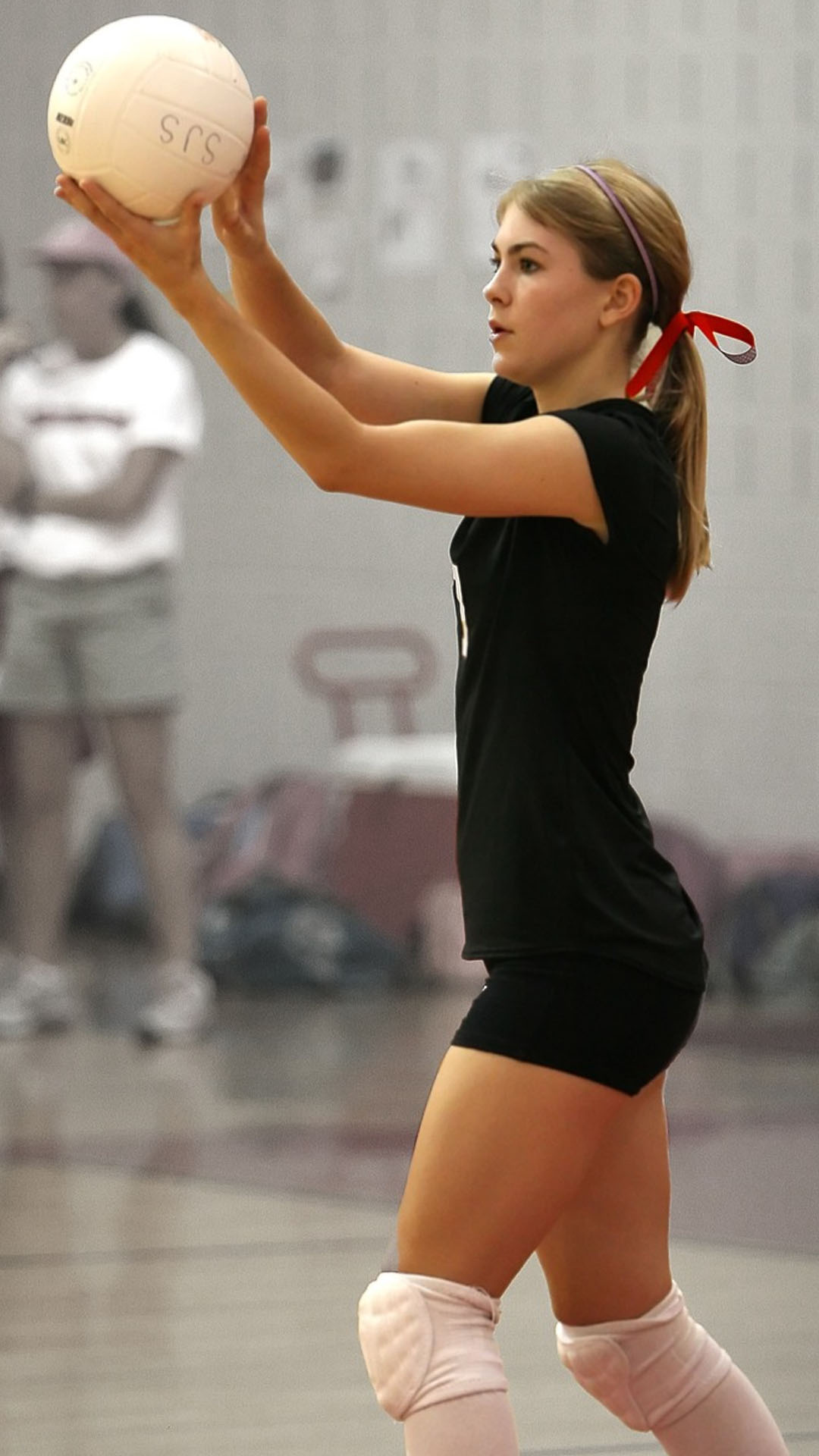 jeune joueuse qui va servir lors d'un match de volley